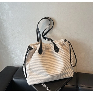 Close-up of cream corduroy tote bag texture with black leather drawstring detail