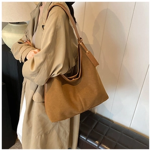 Détail d'un grand sac hobo marron en daim doux avec une large bandoulière confortable