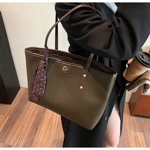 Detailed view of olive green pebbled leather tote with silk scarf and gold hardware
