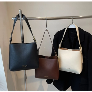 Vue détaillée des sacs seaux en noir, marron et crème avec bandoulière réglable