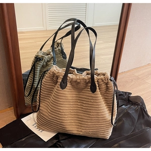 Detail of khaki corduroy tote bag with black leather straps and drawstring closure