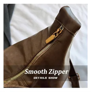 Detail of smooth bronze metal zipper and premium brown faux leather texture on bag
