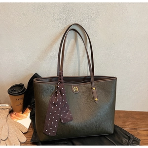 Detail of olive green pebbled leather tote bag with silk scarf and gold hardware