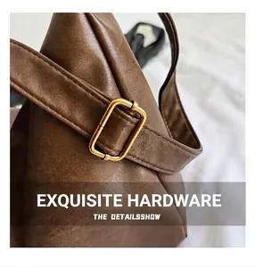 Detailed close-up of premium brown leather bag with golden metallic hardware buckle and stitching