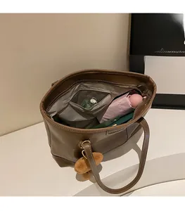 Intérieur spacieux du sac cabas marron montrant le compartiment et la poche zippée