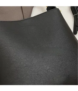 Gros plan du sac à main noir en cuir grainé avec inscription dorée fashion bag