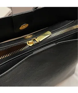 Détail de la fermeture éclair en métal doré et du bouton pression magnétique sur le sac