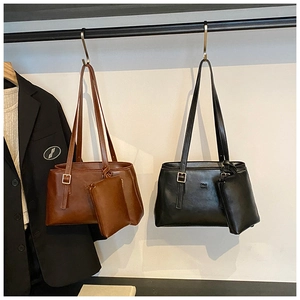 Detail view of retro matte tote bags in dark brown and black with metal buckle and mini pouch
