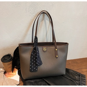 Detailed view of brown lychee grain leather tote bag with silk scarf and logo