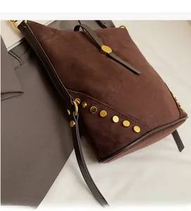 Detailed macro view of the brown suede surface with gold stud accents and metal buckle