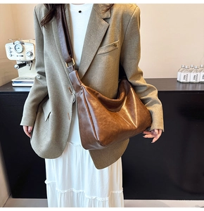 Close-up of soft brown faux leather texture and crescent shape on a vintage shoulder bag