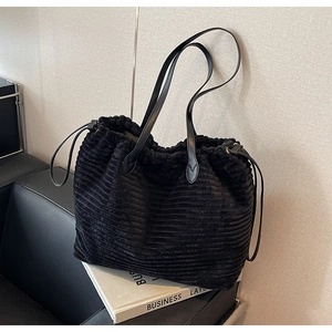 Detail of black corduroy tote bag showing drawstring design and premium ribbed texture