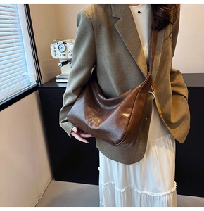 Detail of a deep coffee hobo bag with vintage texture and soft leather finish