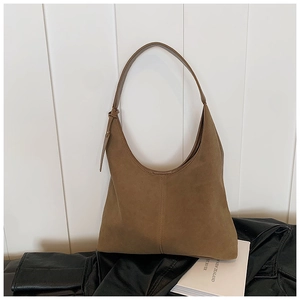 Détail du sac cabas en daim kaki foncé montrant la texture lisse et la bandoulière minimaliste