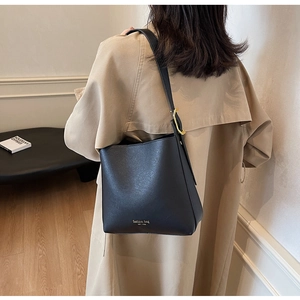 Détail du sac seau noir en cuir avec lettrage doré et boucle métallique de haute qualité