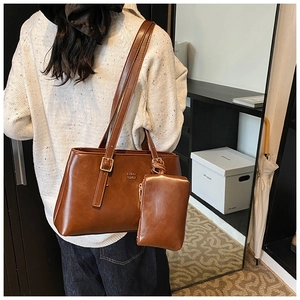 Detail of vintage brown tote bag set with matching small pouch and metallic hardware