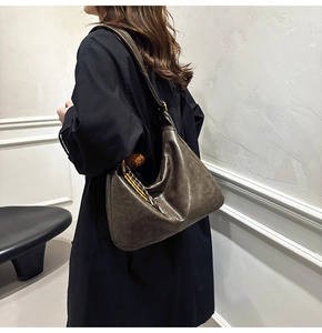 Detail of dark brown hobo bag with vintage texture and stylish checkered scarf charm