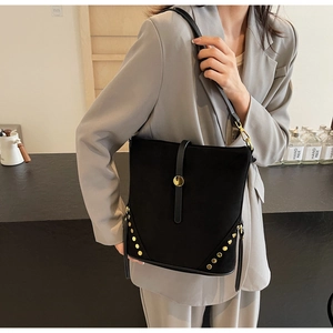 Dettaglio borsa a tracolla vintage in pelle scamosciata nera con rivetti dorati e fibbia