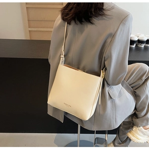 Sac seau chic en cuir crème avec logo New York imprimé dans un décor urbain et élégant