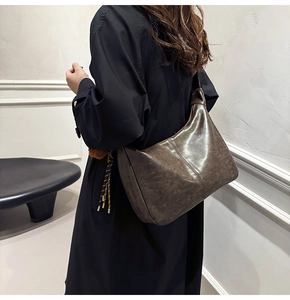 Deep brown vintage leather crescent bag worn over the shoulder for a chic commute style
