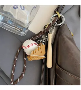 Detalle de un llavero de béisbol con guante y bate colgado en un bolso de cuero café