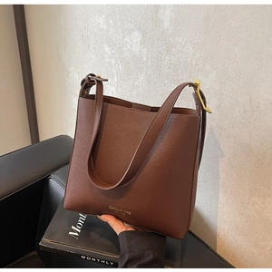 Détail du sac seau en cuir PU marron avec logo doré Fashion Bag New York et boucle