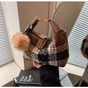 Detail der Vintage-Plüschtasche mit Karomuster, brauner Pelzoptik und weichem Pompon-Anhänger
