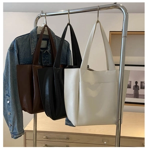 Detailed close-up of large minimalist tote bags in brown, black and white leather textures