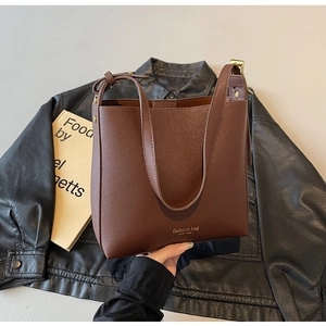 Vue détaillée du sac cabas en cuir marron foncé avec texte New York sur fini mat