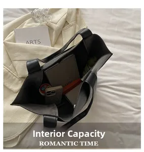 Macro shot of black tote bag showing internal capacity with umbrella and phone inside