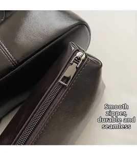 Dettaglio della cerniera in metallo argento su borsa tote vintage in pelle marrone