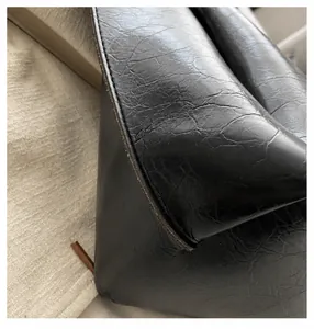 Macro detail of high-quality black leather tote bag with neat stitching and smooth edges
