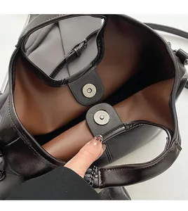 Dettaglio della chiusura magnetica e della trama della pelle cerata della borsa tote