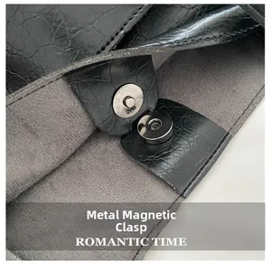 Detail view of the silver hardware magnetic clasp and textured leather on tote bag