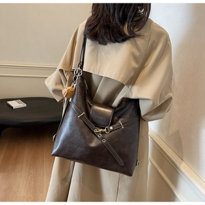 Detalle del bolso bandolera vintage en cuero sintético marrón con hebilla dorada