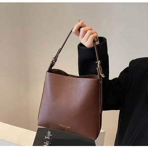 Détail du sac seau marron mat avec boucle dorée et logo Fashion Bag New York