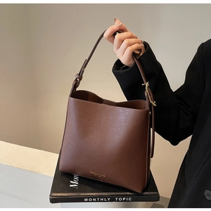 Détail du sac seau en cuir marron foncé avec logo doré fashion bag New York