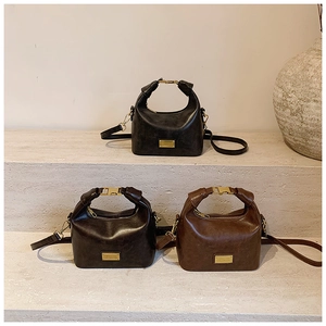 Detailed close-up of retro mini dumpling bags in black, dark coffee, and caramel leather