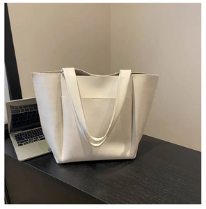 Detail of white PU leather tote bag with large front pocket and wide shoulder straps