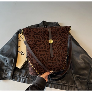 Dettaglio borsa a secchiello leopardata con rivetti dorati e tracolla in pelle