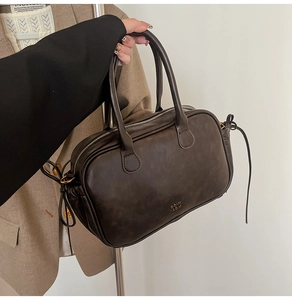 Detail of dark brown vintage Boston bag featuring drawstring sides and gold logo