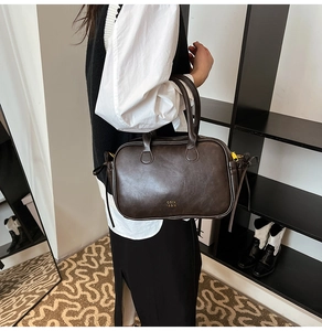 Detail of a dark brown vintage doctor bag with top handle and gold zipper hardware