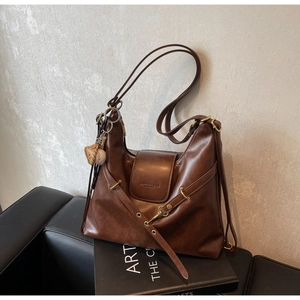 Detalle del bolso hobo de cuero marrón retro con hebilla metálica y colgante