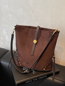 Borsa a secchiello in camoscio marrone con borchie dorate su libro, stile vintage a spalla