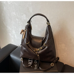 Detalle del bolso tote de cuero marrón oscuro con hebilla metálica y logo de moda