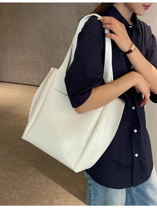 White minimalist PU leather tote bag with large front pocket and long shoulder straps