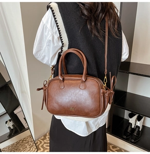 Brown vintage leather square handbag with dual handles and adjustable shoulder strap