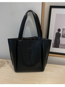Minimalist black oversized tote bag in glossy leather for chic daily commuting