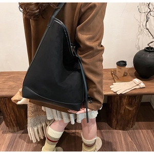 Chic black hobo bag shown in a cozy autumn setting with a model and warm fall aesthetics