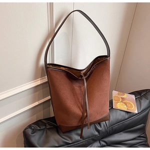 Detail of dark brown tote bag with suede and smooth leather patchwork and ties